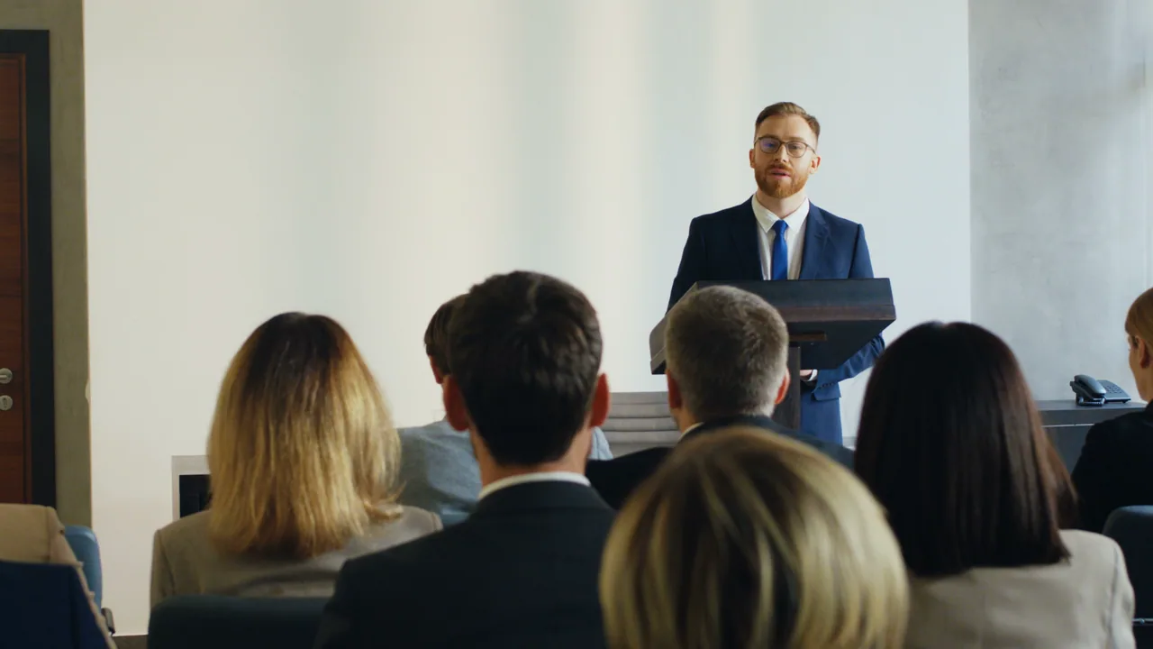 Speaker presenting to a conference audience.